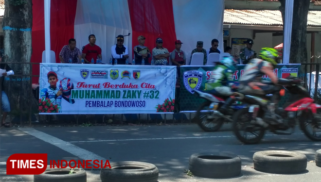 Baliho ucapan duka cita untuk pebalap internasional road race asal Bondowoso M Zaky terpampang dipingir area balap, dalam Balap Motor Nasional Kodim 0822 Cup. (FOTO: Moh Bahri/TIMES Indonesia) 