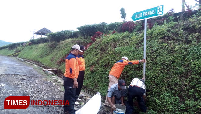 Petugas BPBD Kabupaten Probolinggo, Jawa Timur, saat memasang rambu peringatan bencana longsor. (FOTO: BPBD Kabupaten Probolinggo for TIMES Indonesia)