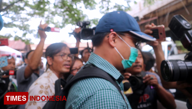 Dua penyidik KPK yang diduga membawa barang bukti baru saja keluar dari Kantor Subdit III Tipidkor Mapolda Jatim dengan pengawalan, Jumat (15/3/2019). (FOTO: Lely Yuana/TIMES Indonesia)