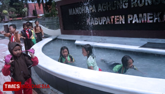 Sekelompok anak SD mandi di kolam taman aspirasi rakyat halaman pendopo Ronggosukowati Kabupaten Pamekasan.(Foto: akhmad syafii/TIMES Indonesia)