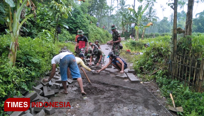 Pekerjaan fisik makadam dan pavingisasi yang dikerjakan satgas TMMD 104/0824/Jember bersama warga dusun paleran, Sabtu (16/03). (FOTO: AJP/TIMES Indonesia)