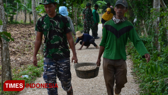 Gotong royong antara Satgas TMMD Kodim 0827/Sumenep bersama warga menyelesaikan pembuatan aspal di Desa Batuputih Laok Sumenep, Minggu (17/3/2019).