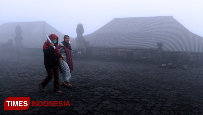 Dua warga Desa Wonokerso berjalan di tengah guyuran hujan abu vulkanik Gunung Bromo (FOTO: Iqbal/TIMES Indonesia)