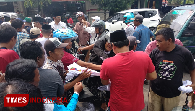 Warga dan pedagang di Pasar 17 Agustus Pamekasan berebut kaos Jokowi-Ma'ruf. (Foto: Putera Khafi/TIMES Indonesia)