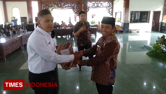 Wakil bupati Pamekasan saat menyerahkan petikan surat keputusan (SK) pengangkatan pada salah satu calon pegawai negeri sipil (CPNS). (FOTO:akhmad syafii/TIMES Indonesia)