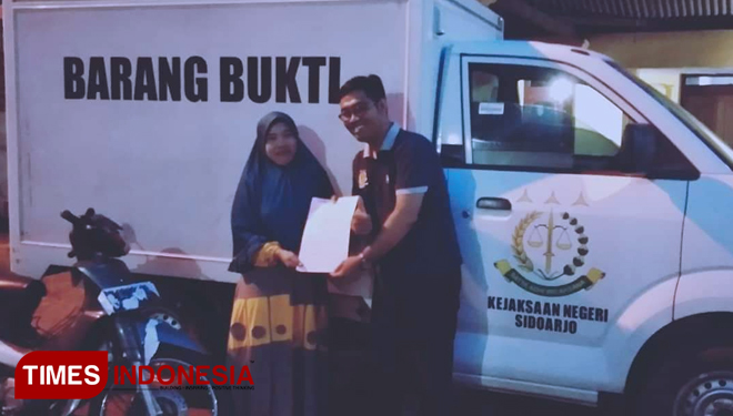 Petugas dari Kejari Sidoarjo saat menyerahkan barang bukti langsung ke rumah warga. (FOTO: Rudi/TIMES Indonesia)
