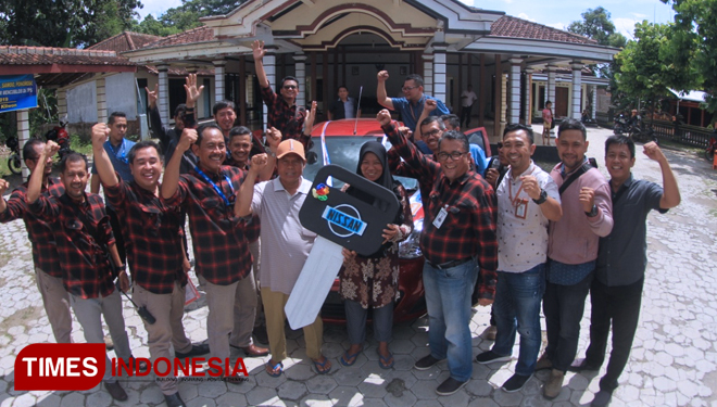 Musani beserta istri dan pemimpin dan karyawan BRI  Cabang Ponorogo foto bersama usai penyerahan hadiah mobil. (FOTO: Evita Mukharohmah/TIMESIndonesia)