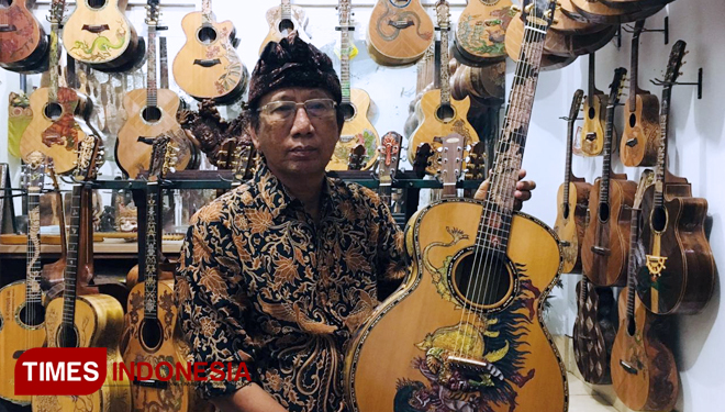 I Wayan Tuges membawa gitar ukir Blueberry Barong karyanya. (FOTO: I Wayan Tuges for TIMES Indonesia) 