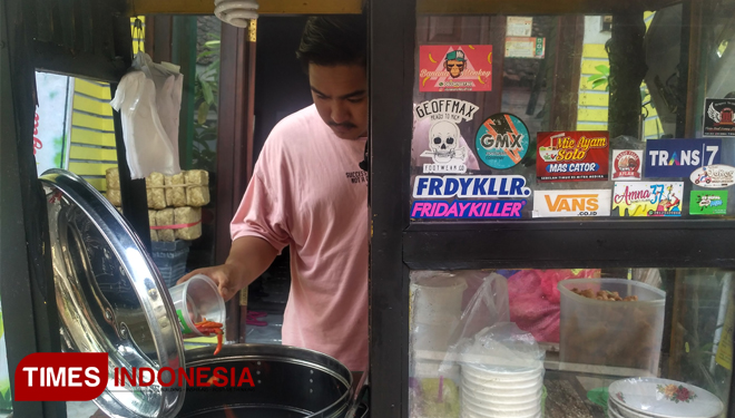 Pemilik Bakso Aflah, kuliner bakso super pedas sedang menuangkan cabai ke dalam kuah bakso (FOTO: Moh Bahri/TIMES Indonesia) 
