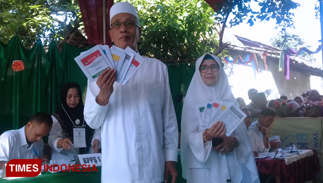 Bupati Bondowoso Drs KH Salwa Arifin didampingi Ny. Siti Maimunah Salwa Arifin, saat menyalurkan hak suaranya di TPS 01 Desa Tangsil Wetan (FOTO: Moh Bahri/TIMES Indonesia)