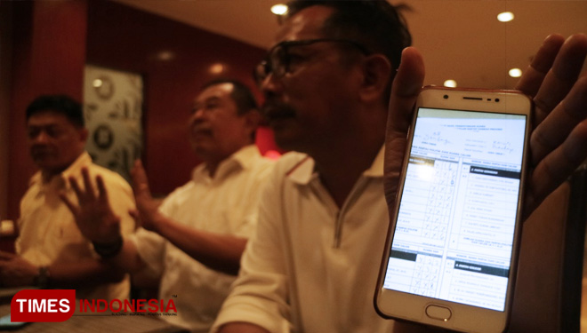 Musyafak Rouf didampingi Sutadi menunjukkan bukti kecurangan yang dilakukan salah satu partai dalam Pileg 2019 di Surabaya, Sabtu (20/4/2019). (FOTO: Lely Yuana/TIMES Indonesia)