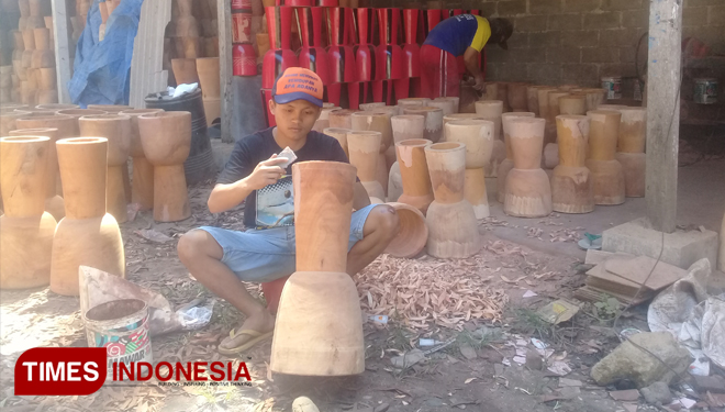 Seorang pengerajin sedang mengecat kendang Jimbe di desa Jeding Kecamatan Sanan Kulon Kabupaten Blitar, Jumat (26/4/2019) (FOTO: Sholeh / TIMES Indonesia)