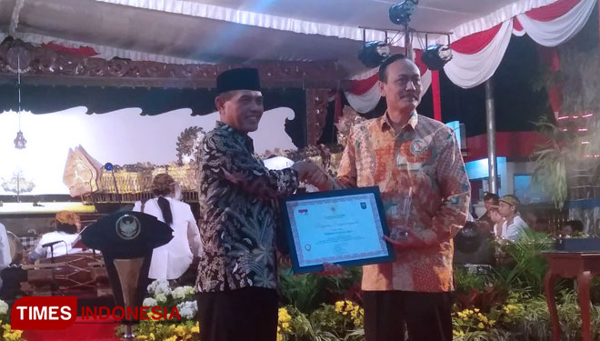 Wali Kota Madiun Sugeng Rismiyanto sebelah kiri menyerahkan piagam penghargaan kepada Sekretaris Daerah Kota Madiun Rusdiyanto sebelah kanan,(FOTO: Pamula Yohar.C/TimesIndonesia).