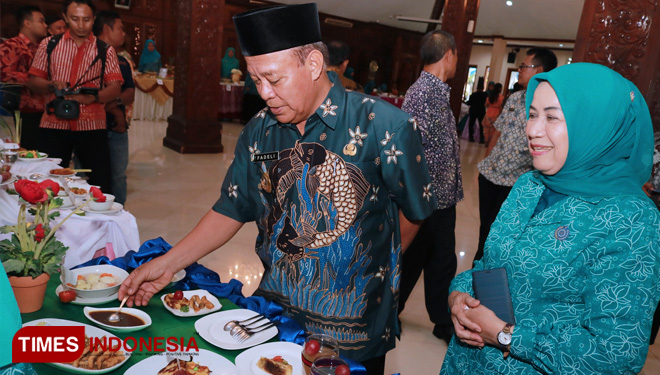 Bupati Lamongan Fadeli didampingi istri mencicipi masakan olahan berbahan dasar ikan, dalam Lomba Masak Serba Ikan, di Pendapa Lokatantra, Selasa, (30/4/2019). (FOTO: Ardiyanto/TIMES Indonesia)