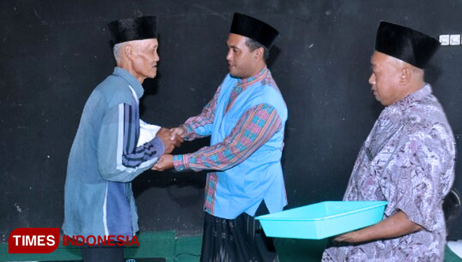 Gus Munif saat membagikan sembako kepada warga. (foto: Erwin Wahyudi / TIMES Indonesia)