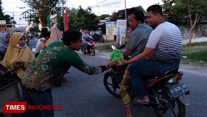 IPNU dan IPPNU Karangrejo saat membagikan takjil di depan RSI Mabarrot Ujungpangkah (Foto: Akmal/TIMES Indonesia)