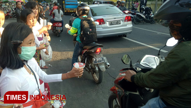 A hindu girl share some food to the moslems on the street. (Picture by: Erwin Wahyudi/TIMES Indonesia)