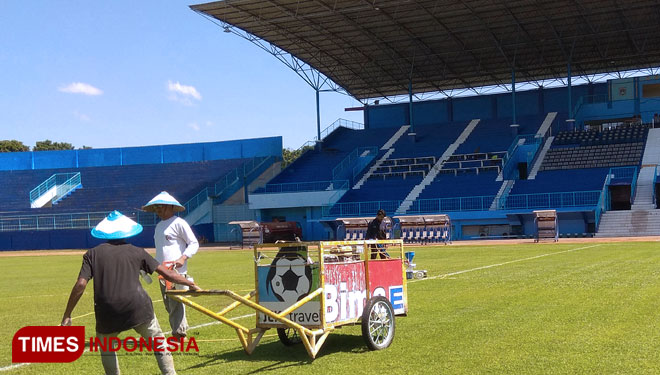 Pekerja Stadion Kanjuruhan, Kabupaten Malang tampak menebalkan garis lapangan pada Sabtu (25/5/2019)