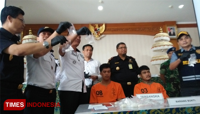 Kedua tersangka bersama barang bukti saat diamankan di Kantor Bea Cukai Ngurah Rai, Bali, Senin (27/5/2019). (FOTO: Khadafi/TIMES Indonesia)