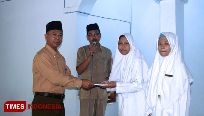 Kepala Pondok Al Islam H. Usman Yudi memberikan penghargaan kepada anak didik berprestasi. (Foto: Marhaban/TIMESIndonesia)
