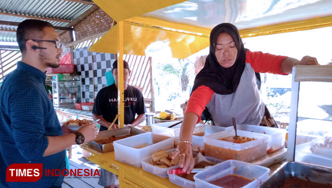 Wati saat sedang melayani pelanggan di warung Tossa di jalan Dokter Sucipto Wlingi, Selasa (11/6/2019).Warung Tossa terkenal dengan masakan super pedas.(Foto: Sholeh/Times Indonesia)
