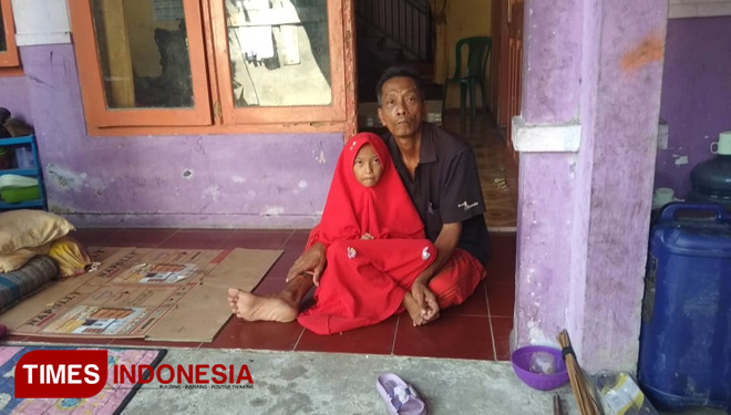 Nisda menemani ayahnya yang menderita stroke, Jum'at (14/6/2019). (FOTO: MFA Rohmatillah/TIMES Indonesia)