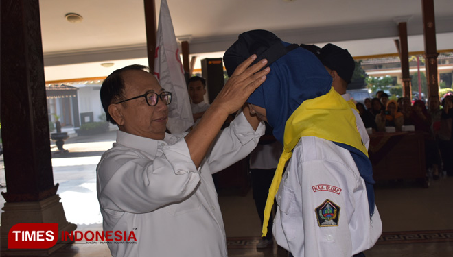 Bupati Blitar memakaikan topi kepada anggota kontingen pada acara pemberangkatan kontingen Jumbara PMR PMI kabupaten Blitar,Kamis (20/6/2019). (FOTO: Sholeh/TIMES Indonesia)