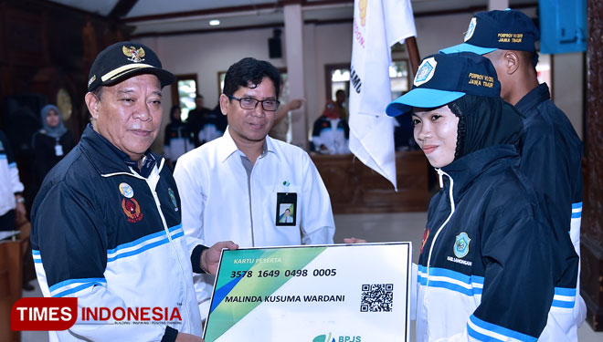 Dua perwakilan atlet Porprov VI, Risky, menerima kartu BPJS secara simbolis dari Bupati Fadeli di Pendopo Lokatantra, Senin (24/6/2019). (FOTO : Ardiyanto/TIMES Indonesia)