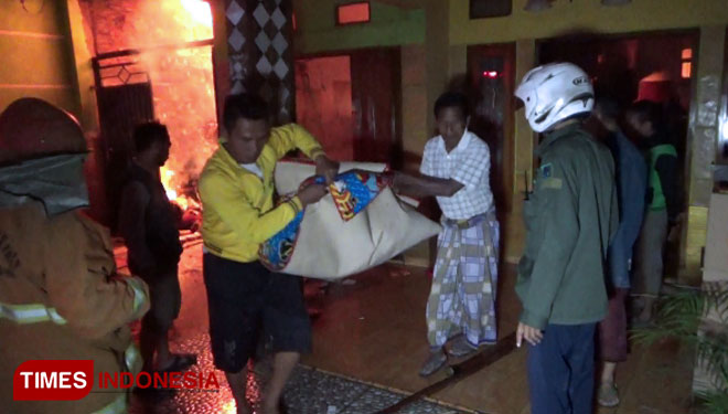 Pemilik rumah dibantu warga mengevakuasi barang yang masih bisa diselamatkan. (FOTO: Happy L. Tuansyah/TIMES Indonesia)