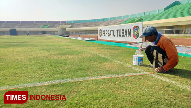 Seorang pekerja perawatan rumput di Stadion Bumi Wali Tuban (BWT) di kompleks Tuban Sport Center (TSC), yang berlokasi di Kelurahan Gedongombo, Kecamatan Semanding, Kamis, (27/06/2019). (FOTO: Achmad Choirudin/TIMES Indonesia)