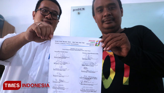Denny Kristanto (kiri) dan Aven Januar (kanan) menunjukkan surat pernyataan sikap siap mendukung visi misi Nawa Cita Jokowi-Ma’ruf Amin selama lima tahun ke depan, Minggu (30/6/2019). (Foto: Lely Yuana/TIMES Indonesia)
