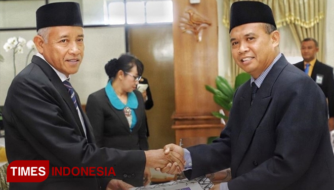 Kepala BKAD Pemkab Sleman, Hardo Kiswoyo SE M.Si (kanan) ketika menerima penghargaan dari Bupati Sleman Sri Purnomo (kiri). (FOTO: Dok. BKAD Sleman/TIMES Indonesia)