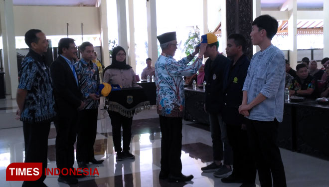 Bupati Bondowoso Salwa Arifin saat memasangkan topi kepada peserta pengabdian. (FOTO: Moh Bahri/TIMES Indonesia)