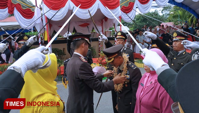 Kapolres Bontang, AKBP Siswanto Mukti saat mengalungkan bunga kepada Kompol Sukandar. (Foto: Kusnadi/ TIMES Indonesia)
