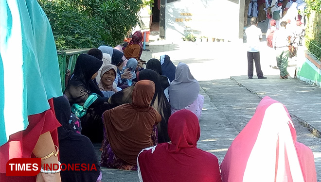 Para orangtua di SD NO. 005 Loktuan Bontang Utara menunggu anak pulang sekolah sejak mengantar tadi pagi, Senin (15/7/2019). (FOTO: Kusnadi /TIMES Indonesia) 