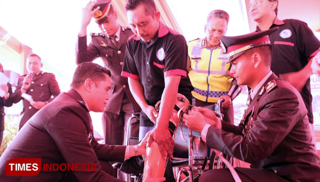 Kapolres Bojonegoro AKBP Ary Fadli didampingi Kasat Lantas AKP Aristianto Budi Sutrisno menyerahkan kaki palsu kepada Nyoto. Rabu (17/7/2019). (Foto: Yudi Handoyo/TIMES Indonesia).