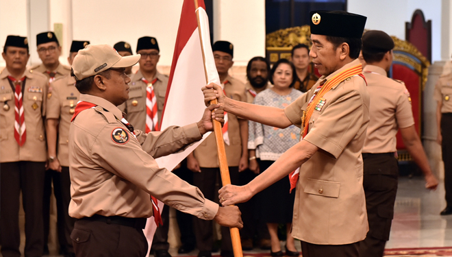 Presiden Jokowi menyerahkan bendera Merah Putih kepada ketua kontingan saat melepas delegasi Pramuka Indonesia pada Jambore Kepanduan Dunia, di Istana Negara, Jakarta, Jumat (19/7/2019). (Foto: Setkab RI)
