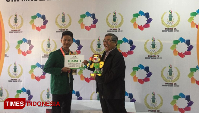 Al Faridho menerima medali emas LKTI Bidang Sosial di Pionir IX. (FOTO: Kusnin Ahmad/TIMES Indonesia)