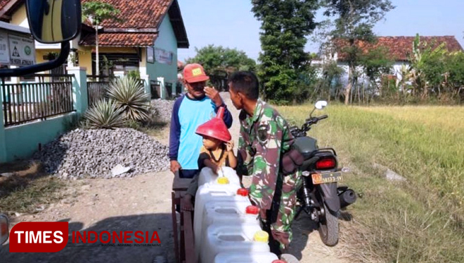 Babinsa Jatimulya Koramil 05 Suradadi, Kecamatan Suradadi, Kabupaten Tegal, Jawa Tengah, bersama salah satu warga yang akan mencari air bersih. (FOTO: AJP TIMES Indonesia)