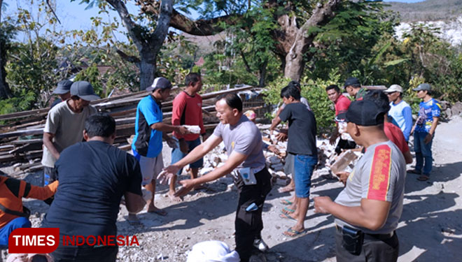 Anggota Polsek Sampung Ponorogo dan warga membantu membersihkan puing-puing rumah yang roboh. (Foto: Marhaban/TIMES Indonesia)