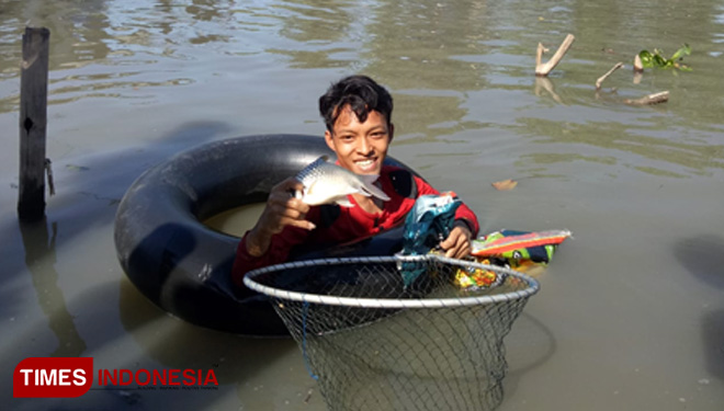 Warga saat mencari ikan di Kali Brantas (FOTO: Akmal/TIMES Indonesia)