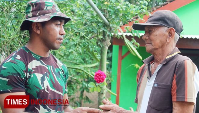 Kakek Subari warga Dasri Tegalsari memberikan mawar kepada Prada Johanis Naranlele kesatuan Yon Armed 8. (Foto: Agung Sedana/ TIMES Indonesia)