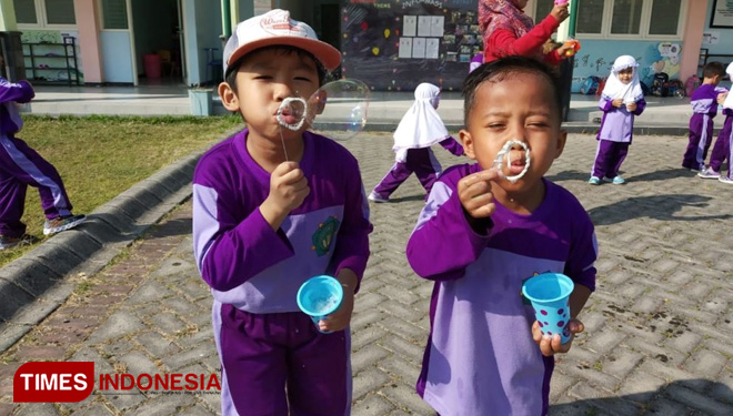 Siswa KB/TK Khadijah Wonorejo tengah asyik bermain gelembung di halaman sekolah, (31/7/2019).