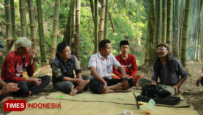 Warga sebaluh pujon dan mahasiswa KKN 114 UMM mengikuti diskusi sambil belajar membuat wayang kulit bersama Mbah Kardjo. (FOTO: AJP/TIMES Indonesia)