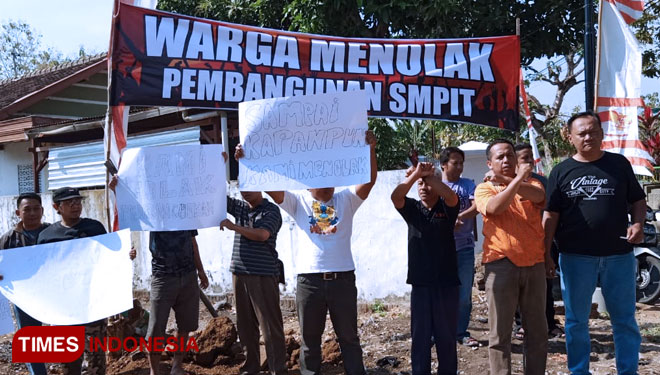 Warga berkumpul dan berorasi di lokasi pembangunan SMPIT di lingkungan Durisawo, Kecamatan Nologaten, Ponorogo.  (Foto: Marhaban/TIMES Indonesia)