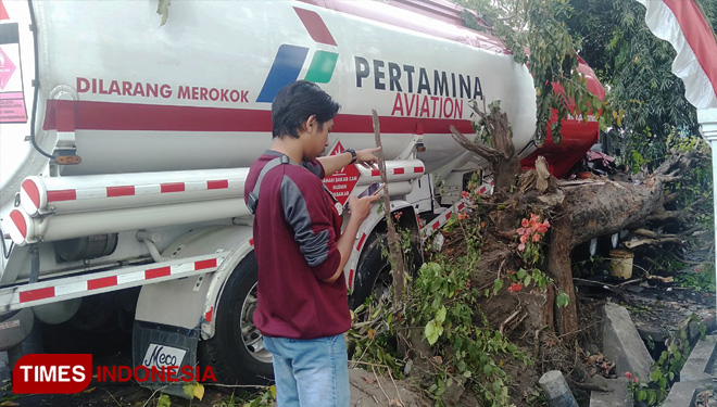 Petugas kepolisian dan anggota Damkar melakukan evakuasi truk tangki Pertamina muatan avtur (bahan bakar pesawat) di Jalan Gatot Subroto, Dusun Kwijenan Desa Jelakombo, Kec/Kab Jombang yang mengalami kecelakaan. (FOTO: Moh Ramli/TIMES Indonesia)