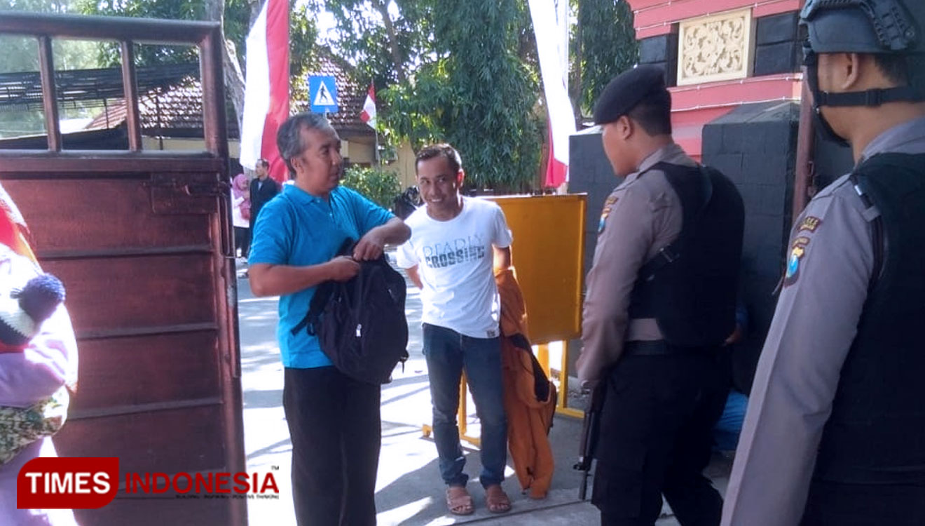Petugas penjagaan di Mapolres Lamongan meminta pengunjung menunjukkan isi tas yang dibawa, Senin (19/8/2019). (FOTO: MFA Rohmatillah/TIMES Indonesia)