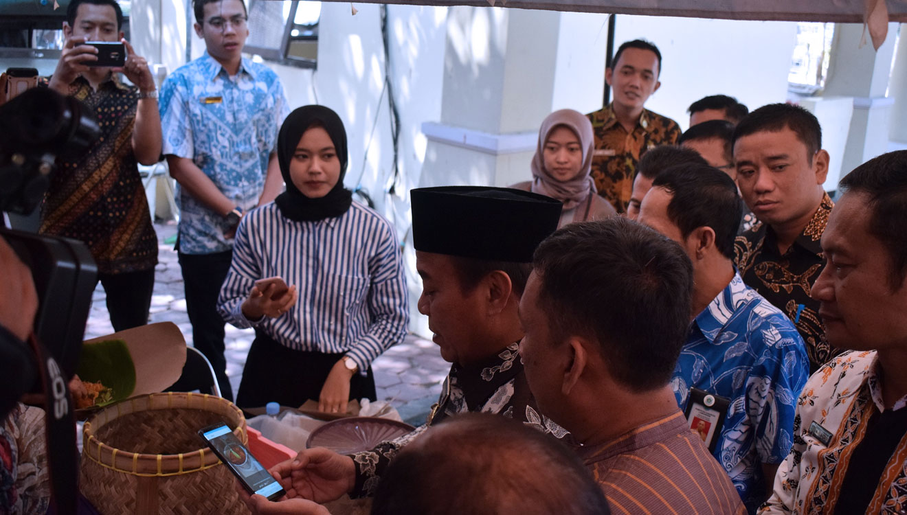 Bupati Lamongan, Fadeli menjajal barcode LA Pay untuk pembayaran nasi boran, Selasa, (20/8/2019). (FOTO: Ardiyanto/TIMES Indonesia)