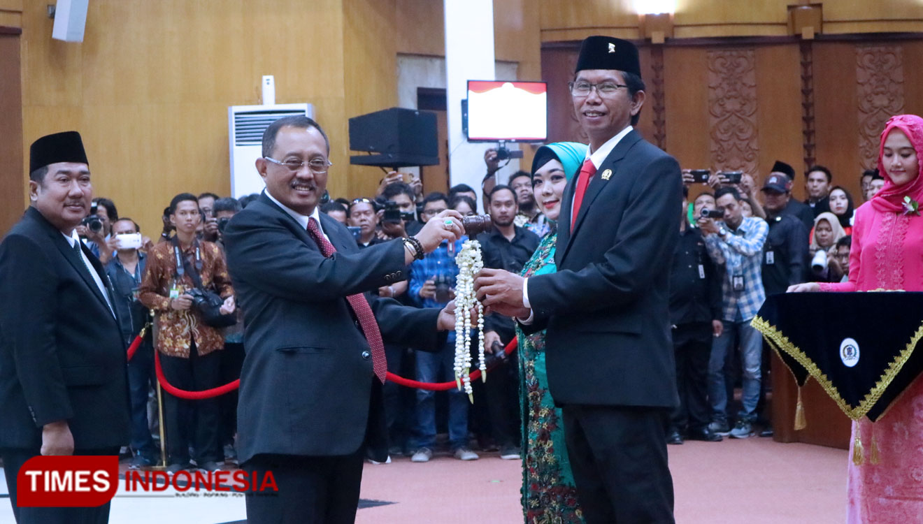 Armuji (kiri) menyerahkan palu sidang kepada Dominikus Adi Sutarwijono (kanan), Ketua DPRD Kota Surabaya sementara, Sabtu (24/8/2019).(Foto : Lely Yuana/TIMES Indonesia).