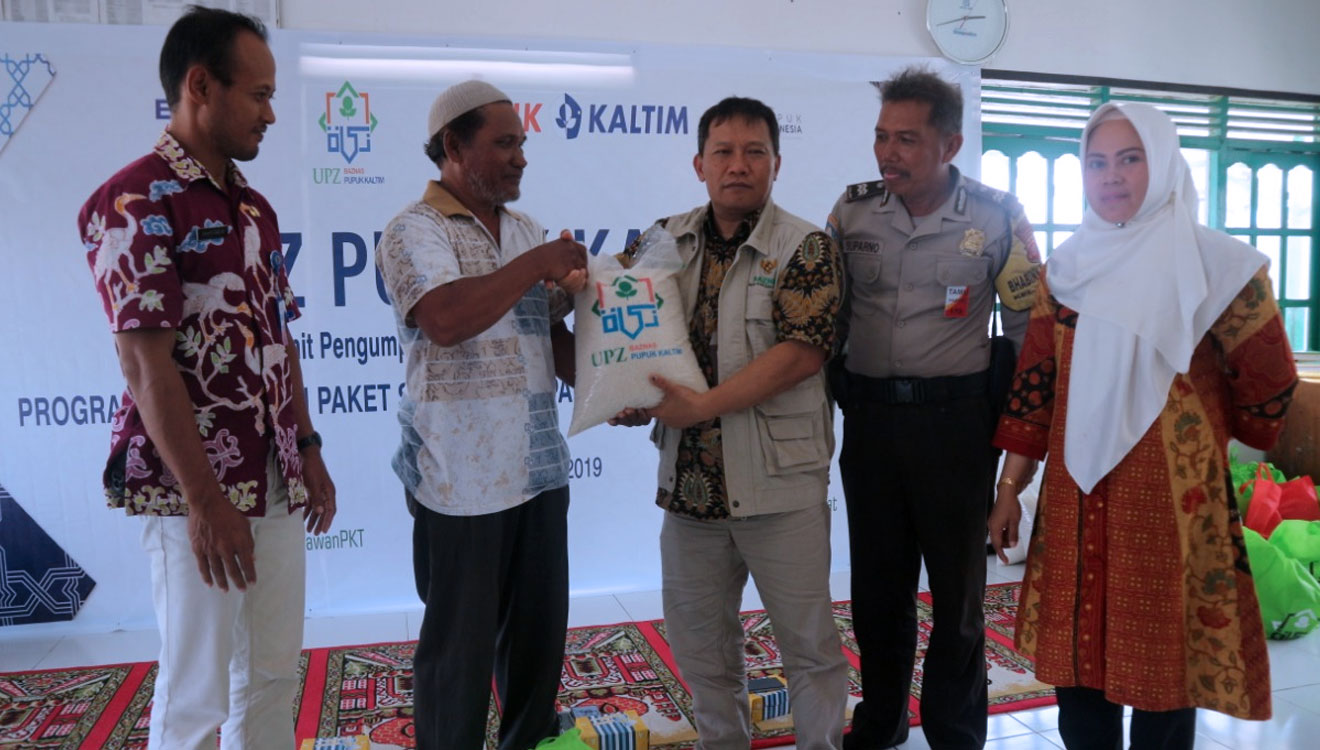 Ketua UPZ Pupuk Kaltim, Nur Sahid menyerahkan paket sembako kepada salah seorang Mustahik. (FOTO: Kusnadi/TIMES Indonesia)